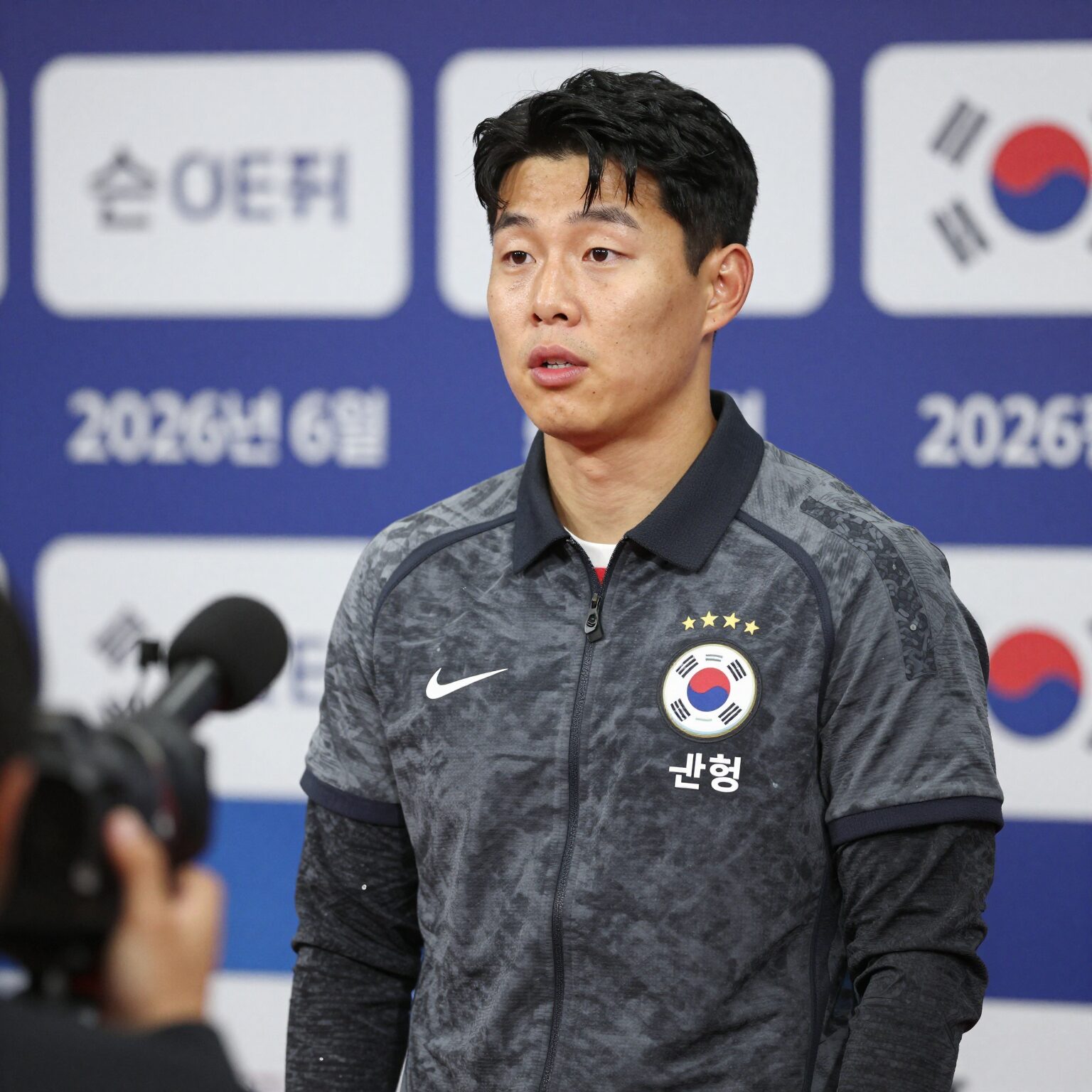 손흥민이 2026년 6월 기자회견에서 마이크 앞에 서서 이야기하고 있는 모습