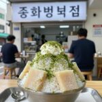 중문 빙수집 추천 인기 메뉴와 방문 팁 중문 빙수집 돌하르방 빙수 매장 내부에서 녹차 빙수를 먹고 있는 모습. 빙수 위에 녹차 가루가 뿌려져 있고 팥과 떡이 보인다.