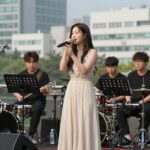 박혜경 히트곡과 청량 보컬의 매력 가수 박혜경이 라이브 무대에서 노래하는 모습. 청량한 보컬과 밴드 연주가 어우러진 현장 사진